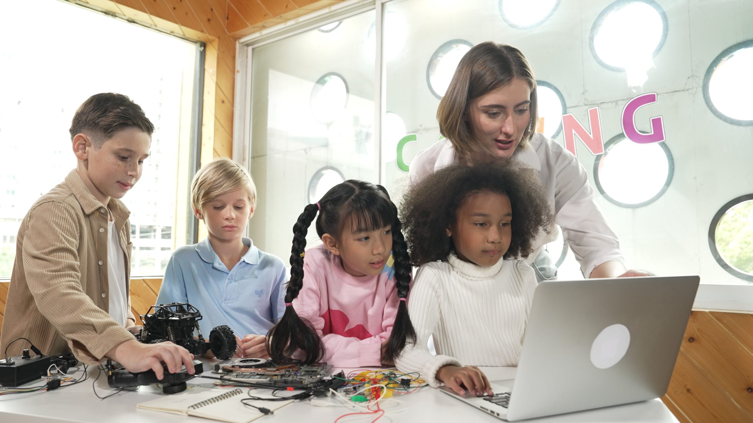 Caucasian teacher praising a student for their work in a classroom focused on culturally responsive teaching